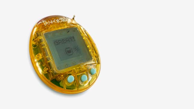 A tamagotchi monster jumps with joy with the word 'GREAT!" flashing on the screen.