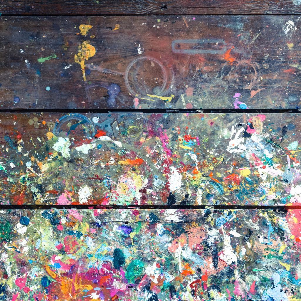 Artists workshop or studio bench covered with splattered paint built up in authentic texture on painted surface